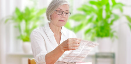 A female patient reads a package leaflet for a medicine.